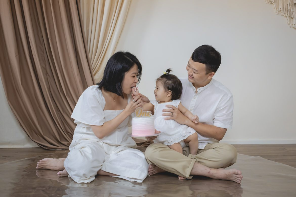 cake smash photoshoot capturing a baby laughing with cake on their hands
