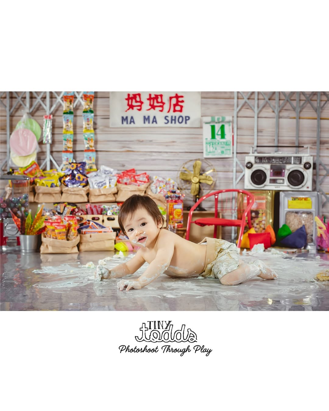 baby playing with cake while lying down on the belly
