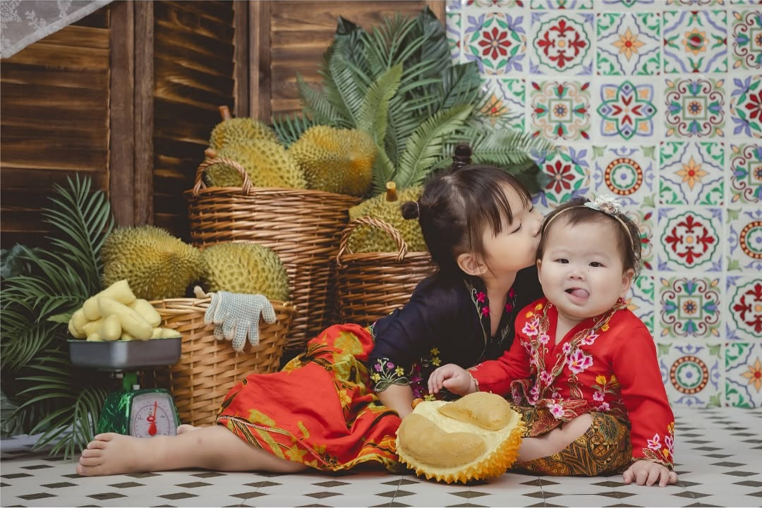 two baby girls wearing baju kebaya