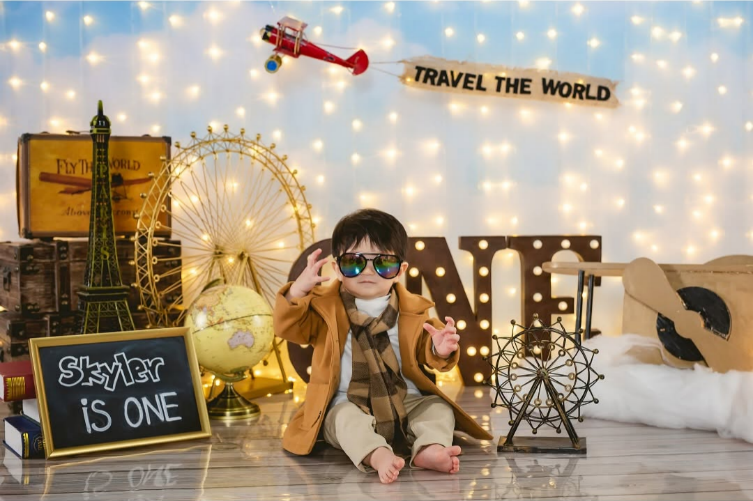 a baby boy dressed in a brown coat and a sunglasses on